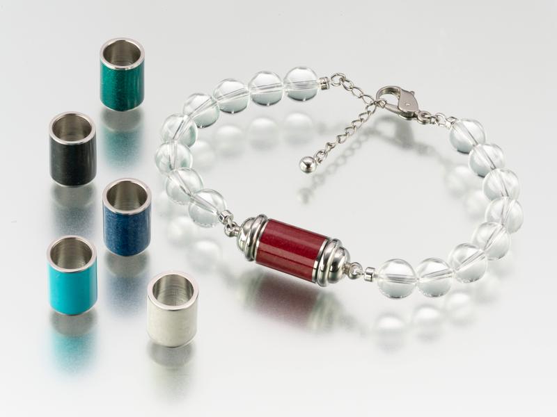 The beautiful Crystal Bead Bracelet with Stainless Steel Cylinder for containing a small amount of your loved one's ashes. Pictured with colourful resin cylinders which can be purchased to personalise your crystal bead bracelet.